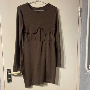 Brun ribbad klänning från Shein - Snygg brun ribbad klänning från Shein med långärmad design. Klänningen har en unik söm över bysten som ger en cool detalj. Perfekt för en stilren look.