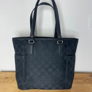 Svart axelväska med mönster - Snygg svart axelväska med diskret mönster! Väskan har en dragkedja upptill och flera innerfickor💗