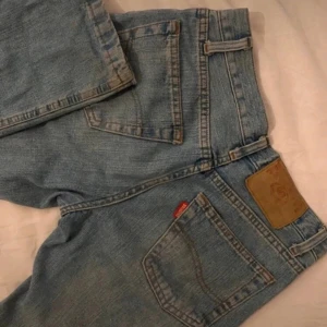 Ljus blåa jeans från rookwood - Snygga jeans från rookwood med klassisk design och fem fickor. De har en låg midja och en bootcut-stil som ger en retro känsla. Perfekta för en avslappnad look.