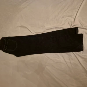 Svarta jeans från Acne - Snygga svarta jeans från Acne med klassisk design och raka ben. De har en knappgylf och femficksmodell. Perfekta för en stilren look. Men dem har en stel matrial på slutat av ena foten fast det är inget man ser