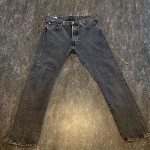 Grå jeansbyxor från Levi's - Snygga grå jeansbyxor från Levi's 501  med klassisk femficksdesign och knappgylf. Perfekta för en avslappnad stil med en rak passform som funkar till det mesta.