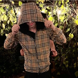 Rutig jacka med huva - Snygg jacka från Burberry med klassiskt rutmönster och huva. Jackan har dragkedja framtill och är perfekt för höst och vår. Den är svart på utsidan med ett rutigt foder i beige,