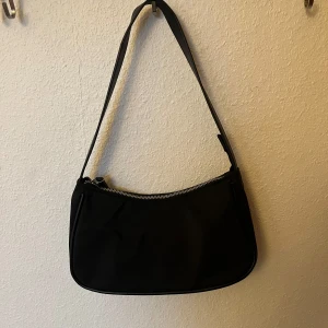 Axelväska  - Axelväska från åhlens med fack innuti. Använd några få gånger- nyskick 