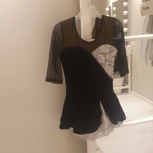 Konståkningsklänning - Denna klänning passar en 10 årung skulle jag säga. Det finns ingen direkt lapp med str men som sagt 10 år. Har en liten defekt längst ner på de vita Skriv till mig om du vill ha foto på det. Hälften i armarna så den är inte klippt. Tror det är sammet