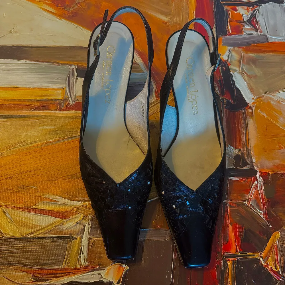 Carmen Lopez med slingback-design. Skorna har en spetsig tå och en elegant klack som ger en stilren look. Perfekta för festliga tillfällen eller en utekväll. De är gjorda i skinn och har en justerbar rem för bästa passform. Kengät.