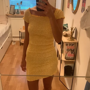 Gul mönstrad klänning från Gina Tricot - Jättesöt klänning från Gina som är ribbad, man kan ha den både off shoulder och med fyrkantig ringning. 