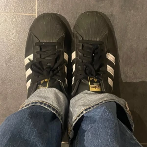 Adidas superstar - Adidas superstar i svart. Nästan helt nya endast använd fåtal gånger. Kommer ej till användning då dom är för stora. Kartong medföljer. Inga skador eller defkter bara så fläcker som kommer och tvättas bort innan de skickas. Pris kan diskuteras. 
