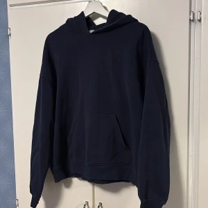 Gina hoodie - Säljer en stilren mörkblå hoodie från Gina Tricot. Den har en klassisk design med en stor ficka framtill och en bekväm huva.  Har använt några gånger och är därför lite urtvättad runt fickan men annars ändå i okej sick💕