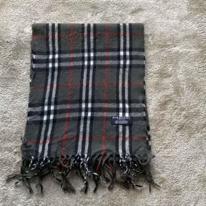 Burberry halsduk  - Helt oanvänd rutig halsduk från Burberry i 100% kashmir. Passar perfekt nu till våren. Mitt pris 449 som är diskuterbart. Kom dm vid intresse eller minsta fundering!