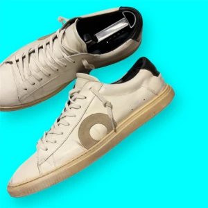 Oliver Cabell - Snygga vita sneakers med en unik rund detalj på sidan. Skorna har snörning och en bekväm passform. Perfekta för en stilren look. Defekter förekommer 