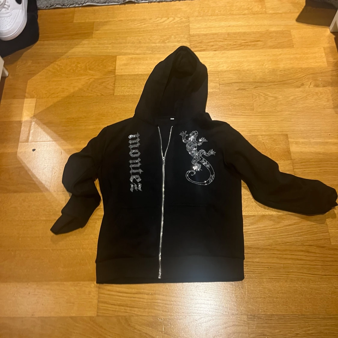 Svart hoodie med glittrig ödla