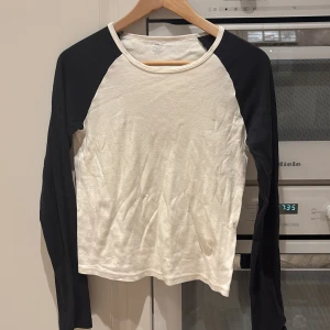 Vit och svart långärmad tröja - Säljer en vit och svart långärmad tröja från Brandy Melville. Tröjan är vit med svarta ärmar och har en enkel och stilren design. Tröjan är i bra skick och väldigt bekväm att ha på sig. Passar perfekt för hösten! Den är Onesize men passar som en XS/S/M.