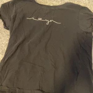 Svart t-shirt från Amisu - Säljer en svart t-shirt från Amisu med ett stilrent tryck på ryggen. T-shirten är kortärmad och passar perfekt för en avslappnad stil. Tillverkad i Turkiet.