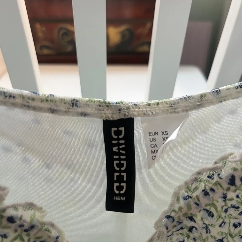Söt blommig klänning från H&M i ljusgrön nyans med små blommor. Klänningen har smala axelband och en åtsittande passform med rynkade detaljer längs hela längden. Perfekt för sommarens varma dagar!. Mekot.
