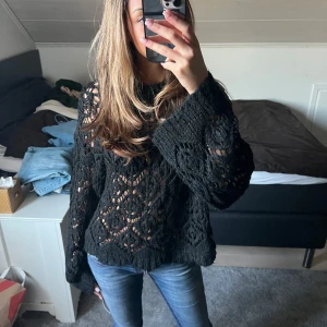 Svart stickad tröja från Zara - Säljer en svart stickad tröja från Zara med ett snyggt hålmönster. Tröjan har långa ärmar och en rund halsringning. Perfekt för lager-på-lager-stil eller som statement-plagg. 🖤Snyggt med ett svart linne under ! 