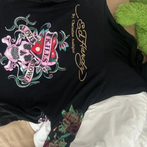 Ed Hardy hoodie  - Ed Hardy hoodie med luva och tryck, alla diamanter sitter kvar. Hoodien är i ett stretchigt material och passar både tjejer och killar.