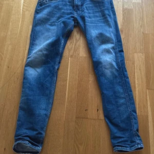 Blå jeansbyxor från Replay - Snygga blå jeansbyxor från Replay, modell Anbass. De har en slim fit passform och klassisk femficksdesign. Perfekta för en stilren look. De är i jättebra skick. Jag säljer för de inte passar längre. Pris kan diskuteras. Storlek 31/32.
