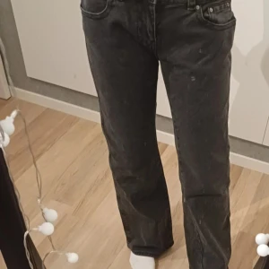 Svarta jeans från Gina tricot - Snygga svarta jeans från Gina tricot i storlek 38. De är baggy med bootcut med fem fickor och knappgylf. Perfekta för en stilren look.