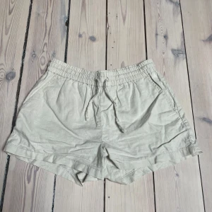 Shorts, linne, beige från Kappahl - Säljer ett par bekväma beige linneshorts från Kappahl. De har en elastisk midja med snörning för justerbar passform. Perfekta för varma sommardagar. 🏖️