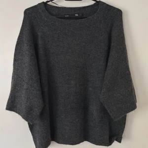 Mörkgrå stickad tröja från 157 - Säljer en mysig mörkgrå stickad tröja från 157. Tröjan har en avslappnad passform med trekvartsärmar och rund halsringning. Perfekt för kyliga dagar. Aldrig använd🩶