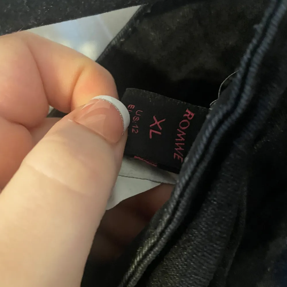 Snygga svarta jeans från Romwe med broderade örnar på bakfickorna. De har en klassisk femficksdesign och knappgylf. Perfekta för en cool och avslappnad stil.. Farkut & Housut.