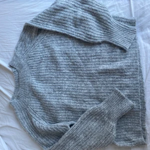 Grå stickad tröja från lager 157 - Mysig grå stickad tröja från lager 157. Perfekt för kyliga dagar med sin mjuka och bekväma passform. Tröjan har långa ärmar och en klassisk rund halsringning.