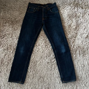 Nudie Jeans - Snygga mörkblå Nudie Jeans i modellen Big Bengt. Storlek 28/30 med en riktigt snygg wash. Paret är i mycket bra skick utan några defekter. Säljs då dem är för små för mig. Skriv vid frågor! 