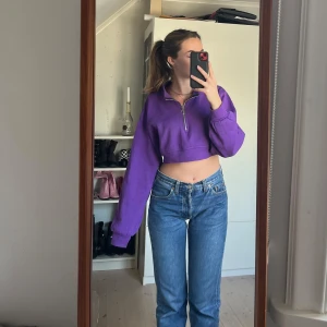 Lina croptop Beyond Retro  - Mysig lila croptop med långa ärmar. Super gosigt material på insidan. Kan  ha dragkedjan uppe eller nere för olika looks. Snygg med mörka mörkblå jeans! Super fint skick