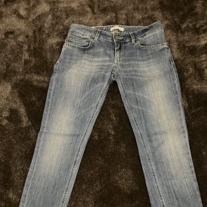 Blå jeans från Dondup - Säljer ett par snygga blå jeans från Dondup. De har en klassisk femficksdesign och en bekväm passform. Jeansen har en lätt tvättad look med subtila slitningar för en trendig stil. Perfekta för både vardag och fest!