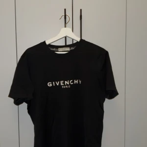 Svart t-shirt från Givenchy - Snygg svart t-shirt från Givenchy med deras ikoniska logga tryckt på bröstet. Perfekt för en stilren look. Tillverkad i mjukt material för extra komfort.