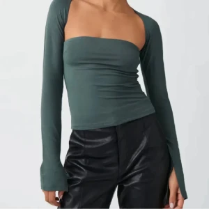  Soft touch square  topp från Gina tricot  - Snygg mörk grön långärmad topp från Gina  med en unik draperad design framtill. Toppen har en tight passform och är perfekt för att ge en stilren look. Aldrig använd.