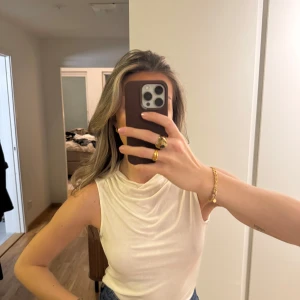 Vit ärmlös topp från & Other Stories - Superfin topp från & Other Stories. Materialet är verkligen superstretchigt och jättemjukt, så passar XS-M. Toppen har en draperad halslinje som ger en elegant touch. Perfekt för att matcha med jeans eller kjol. 🖤