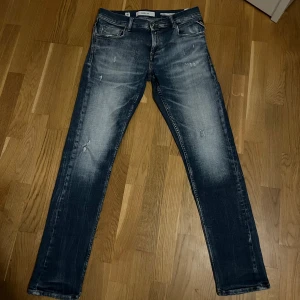 Replay jeans - Snygga blå jeans från Replay med en klassisk straight fit. Jeansen har små feta slitningar vilken gör till en stilren look. Byxorna är 30/32. Skriv vid eventuell frågor.