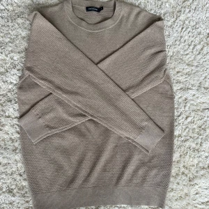 Stickad tröja - En stilren stickad tröja i beige. Storlek M
