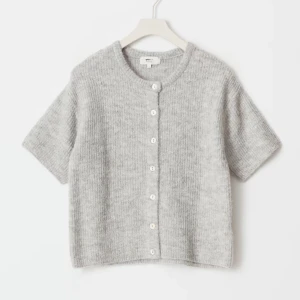 Grå kofta med korta ärmar - Säljer en mysig grå kofta med korta ärmar och knappar framtill. Koftan är helt ny med prislappen kvar då jag köpte fel storlek. Storleken är M🩶