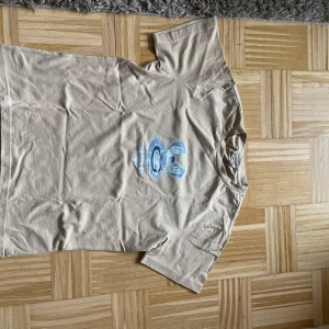 Beige t-shirt med blått tryck - Säljer en weekday tröja med ascoolt tryck