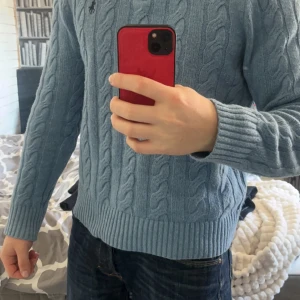 Blå stickad tröja från Polo Ralph Lauren - Säljer denna blåa stickade tröjan från Ralph lauren i riktig bra skick, modellen är 178cm lång,bara att höra av sig vid frågor 