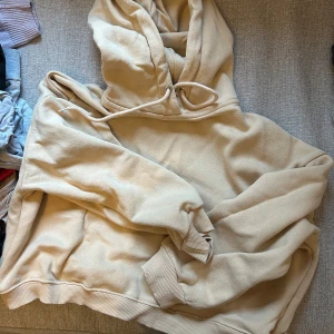 Beige boxig hoodie från 157 - Säljer en mysig beige hoodie från 157 i storlek M. Den har en boxig design med huva och dragsko. Perfekt för en avslappnad stil.