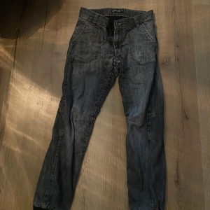 Grå jeansbyxor från Detroit - Snygga grå jeansbyxor från Detroit med en cool tvättad look. Byxorna har en klassisk femficksdesign och knappar i midjan. Perfekta för en avslappnad stil.