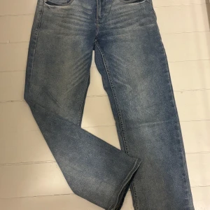 Blå jeans från Levi's - Säljer ett par klassiska blå jeans från Levi's med hög midja och rak passform. De har en snygg tvätt och traditionella fem fickor. Perfekta för en avslappnad stil.