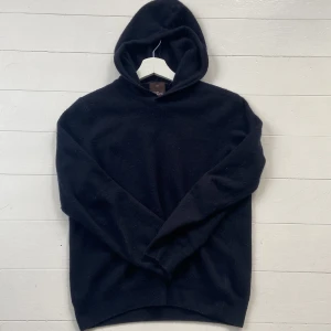 Marinblå hoodie från Oscar Jacobson - Säljer en stilren  hoodie från Oscar Jacobson, den har inga defekter och är ganska liten. Passar nog någon mellan 160-170 skriv vid funderingar