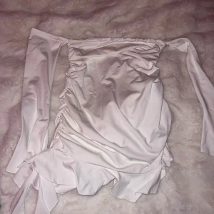 Vit offshoulder klänning - Säljer en stilren vit offshoulder klänning med långa ärmar och volangdetaljer. Aldrig använd