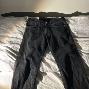 Svarta jeansbyxor - Snygga svarta jeansbyxor med klassisk femficksdesign och knappgylf. Perfekta för en stilren look. Passar till många olika outfits och tillfällen.