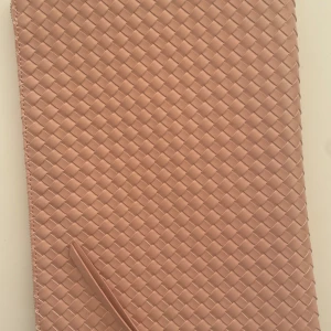 Rosa flätad datorfodral  - Snyggt rosa datorfodral med flätat mönster och dragkedja. 