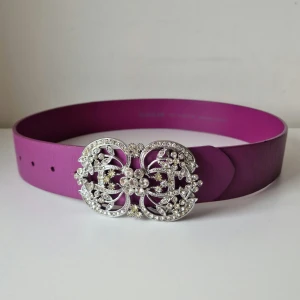 Lila skärp från Saddler - Snyggt lila skärp från Saddler i äkta läder med en glittrig, detaljerad spänne i silver. 75 cm.