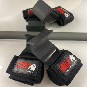 Svarta tränings- hooks från Gorilla Wear - (Endast testade två gånger! Orginalpris 299kr) Säljer ett par svarta tränings- hooks från Gorilla Wear. De har en robust design med justerbara remmar och en krok för extra grepp vid lyft. Perfekta för gymmet och styrketräning. Märket är tydligt synligt med röd och vit logga. Säljer på grund av att de inte används då jag har bättre alternativ!