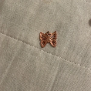 Roséguld fjärilshänge - Elegant fjärilshänge i roséguld med detaljerade utskärningar. Perfekt för att skapa ett unikt smycke eller som en fin detalj på ett armband eller halsband.