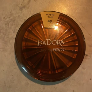 Isadora Smoothing Powder Matte Tan 48 - Säljer ett Isadora Smoothing Powder i färgen Matte Tan 48. Perfekt för en jämn och matt finish. Kompakt förpackning med inbyggd spegel, idealisk för touch-ups under dagen.