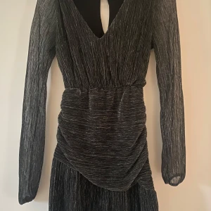 glittrig klänning från Meet x Tiger - Snygg svart glittrig klänning från Meet x Tiger med v-ringning och långa ärmar. Den är andvänd 2 gånger. Perfekt för tex nyår eller fest😍 hör av dig vid funderingar eller frågor. 
