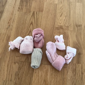 Söta babystrumpor i olika färger - Ett set med flera par babystrumpor i mjuka färger. Inkluderar rosa och beige strumpor, några med spetsdetaljer. Perfekta för små fötter och gjorda i bekvämt material.